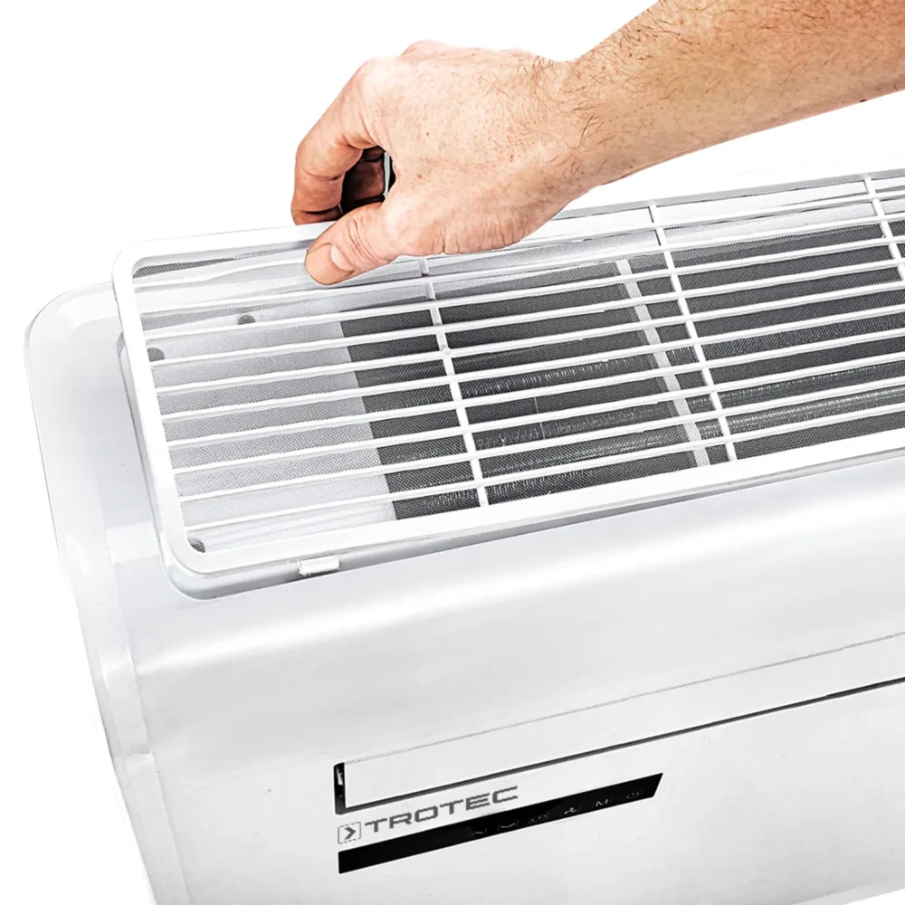 Hånd der fjerner gitteret fra en airconditionenhed